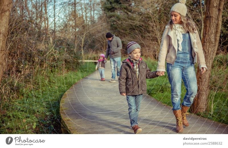 Happy family walking together holding hands in the forest Lifestyle Beautiful Winter Child To talk Human being Boy (child) Woman Adults Man Parents Mother