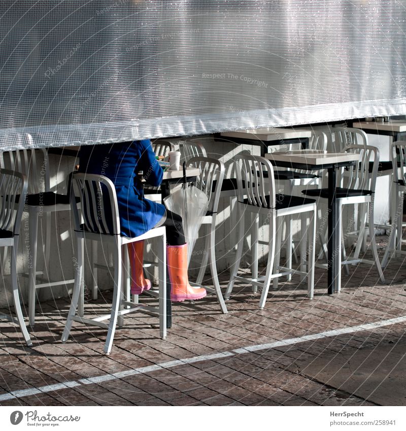 After the rain Drinking Human being Woman Adults 1 Sun Rain Tel Aviv Israel Town Blue Silver Coat Umbrella Rubber boots Sidewalk café Coffee Sit Colour photo