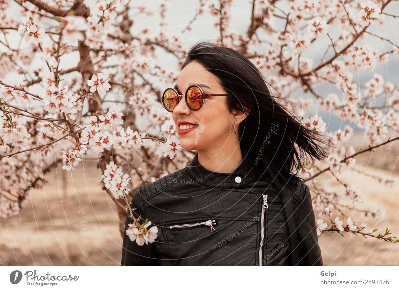 Pretty brunette girl Style Happy Beautiful Face Garden Human being Woman Adults Nature Tree Flower Blossom Park Fashion Jacket Leather Sunglasses Brunette