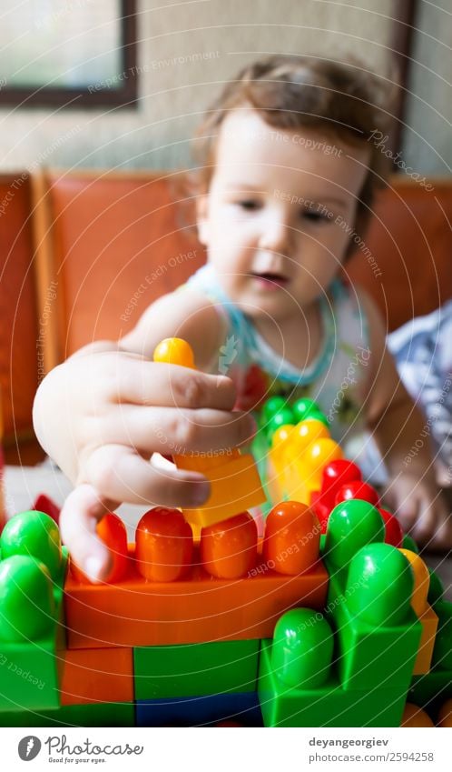 Little girl playing with toy blocks Joy Happy Leisure and hobbies Playing Child Infancy Hand Building Toys Plastic Sit Small Colour Creativity kid construction