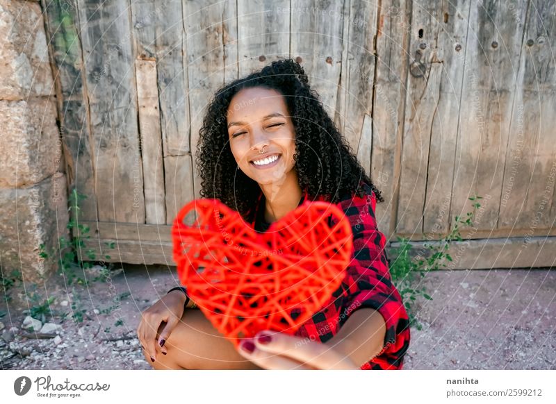 Beautiful young woman holding a red heart Lifestyle Style Joy Hair and hairstyles Healthy Wellness Well-being Contentment Human being Young woman