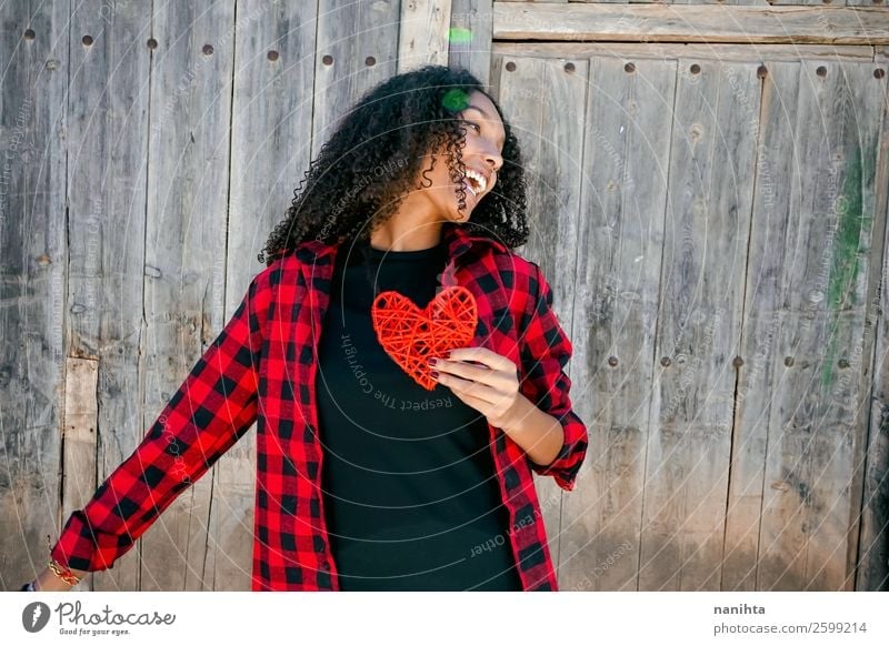 Beautiful young woman holding a red heart Lifestyle Style Joy Hair and hairstyles Healthy Wellness Well-being Human being Feminine Young woman