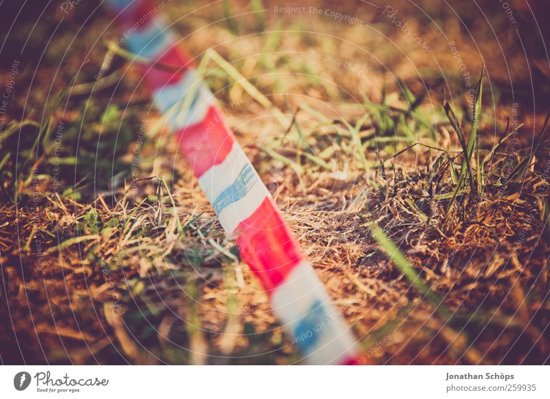 Barrier Tape III Environment Nature Grass Meadow Brown Green Red White Criminality Crime thriller Border Border crossing Striped Football pitch Exterior shot