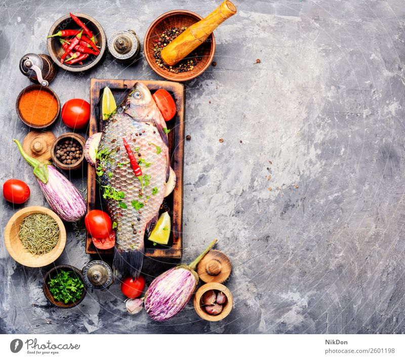 Fresh raw fish and food ingredients carp seafood fresh meal healthy cutting board cooking pepper tomato vegetable preparation spice salt diet uncooked closeup