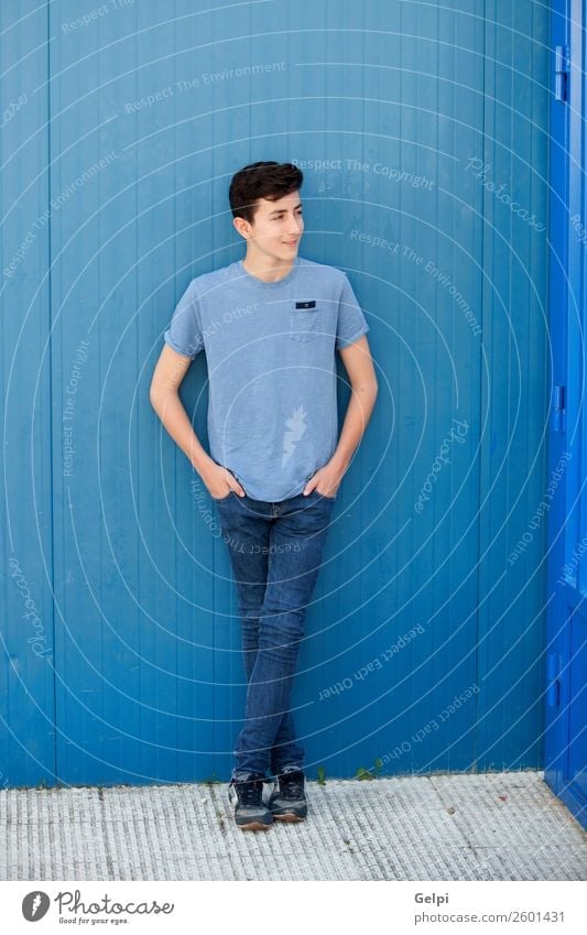 Portrait of a teenager rebellious man with a blue background Lifestyle Style Happy Beautiful Face Human being Boy (child) Man Adults Youth (Young adults)