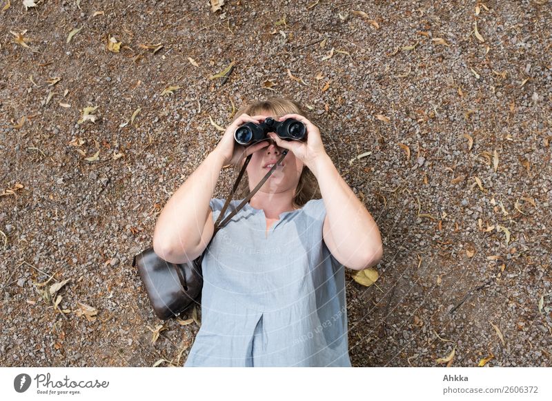 Young woman in blue dress looks through binoculars on neutral background Education Science & Research Adult Education School Professional training