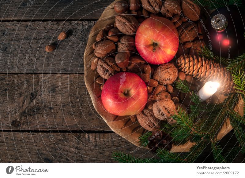 Platter with nuts and apples with Xmas decor Apple Happy Winter Decoration Table Candle Retro Tradition Christmas settings above view background candlelight