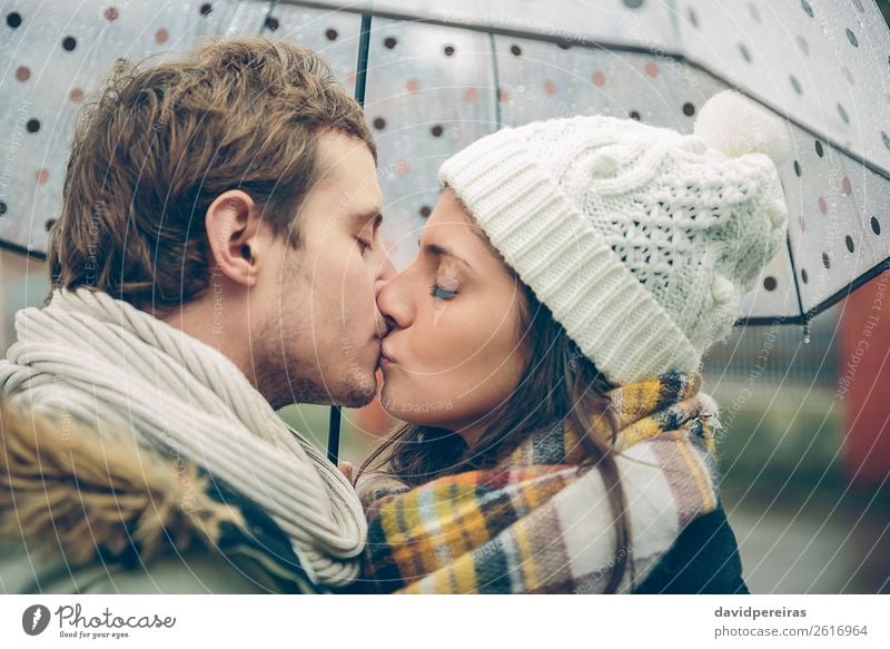 Young couple kissing outdoors under umbrella in a rainy day Lifestyle Happy Beautiful Winter Human being Woman Adults Man Family & Relations Couple Lips Autumn