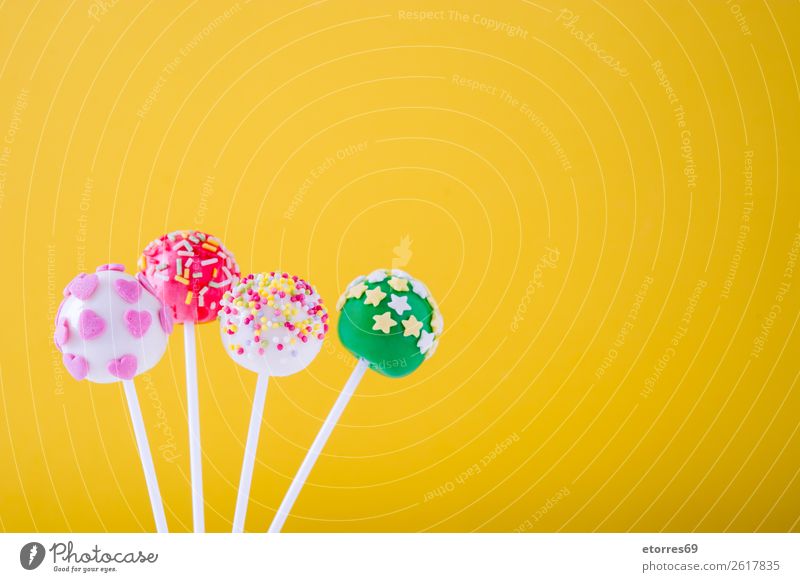 Sweet colorful cake pops on yellow background Baked goods Cake Candy Colour Multicoloured Food Food photograph Lollipop Baking Yellow Dog food Stick Pink