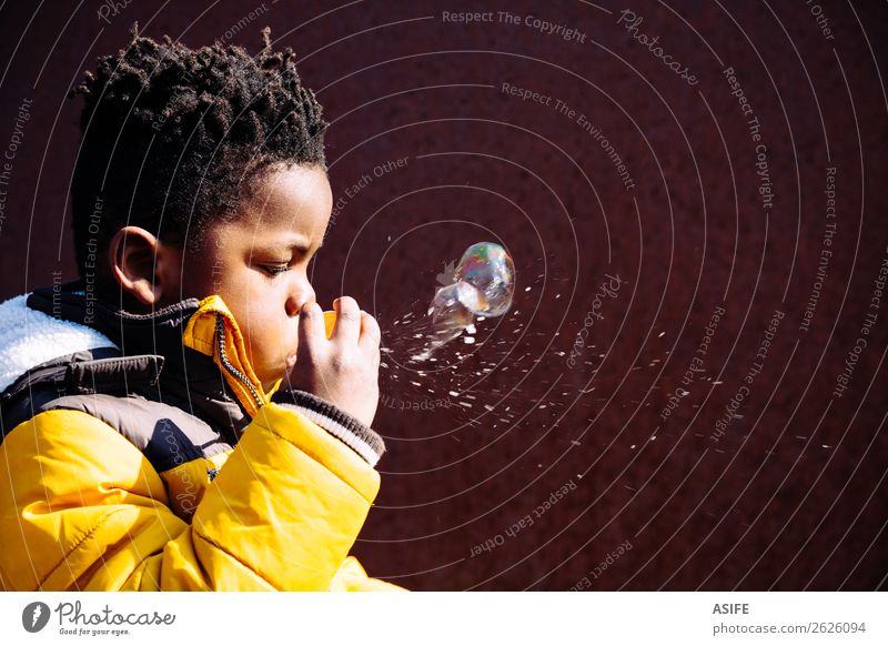Blowing bubbles is not easy when you are a little child Joy Happy Leisure and hobbies Playing Winter Child Boy (child) Man Adults Infancy Autumn Street Afro