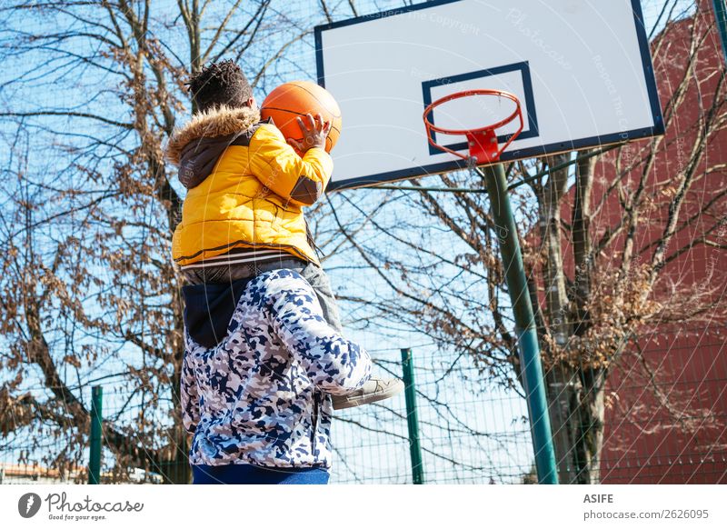 Little boy on daddy´s shoulder playing basketball Joy Happy Relaxation Leisure and hobbies Playing Winter Sports School Boy (child) Parents Adults Father