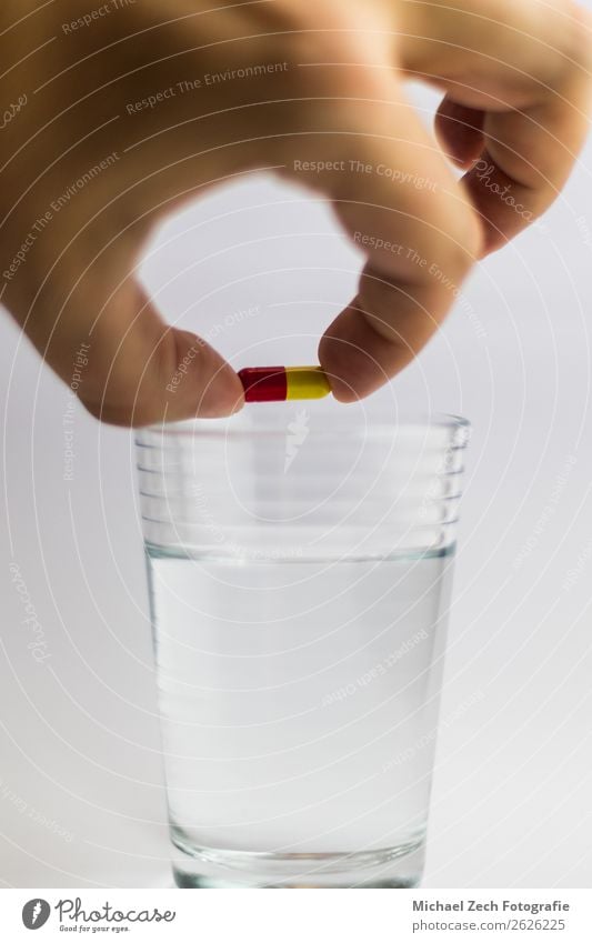 men gives a red and yellow colored pill in a glass of water Bowl Medical treatment Illness Medication Science & Research Hand Wood Blue Yellow Pink White Colour