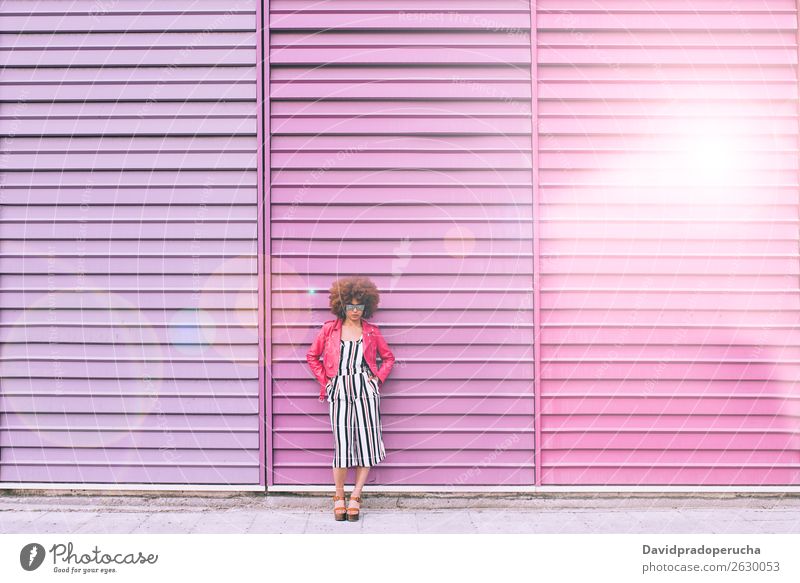 Mixed race woman in a multicolor wall background Woman Smiling Portrait photograph Black Lifestyle Background picture Multicoloured multiethnic Pink