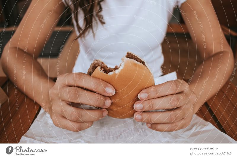 Young girl holding fast food burger Bread Roll Lunch Diet Fast food Lifestyle Vacation & Travel Human being Hand Street Fashion To hold on Delicious Appetite