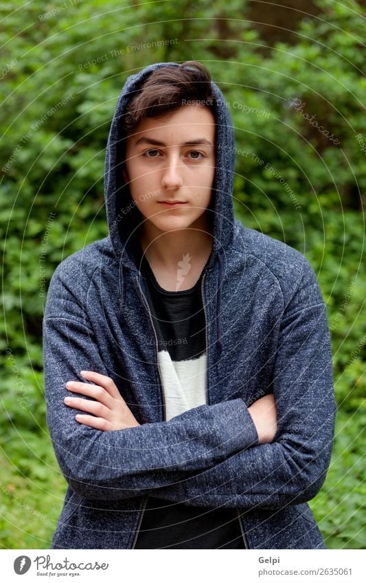 Serious teenager guy with hood on the head Face Child Human being Boy (child) Man Adults Youth (Young adults) Plant Park Sadness Cool (slang) Dark Black