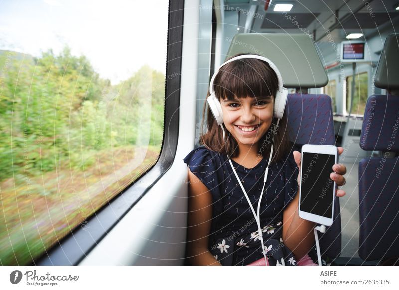 She is happy with her smart phone travelling by train Joy Happy Beautiful Leisure and hobbies Vacation & Travel Trip Music Child Headset PDA Screen Technology