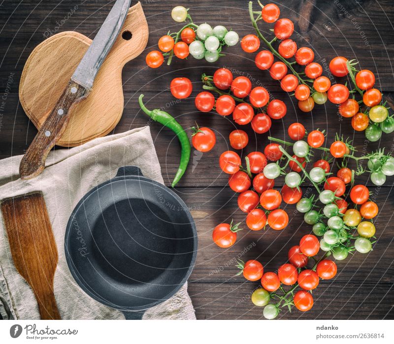 cast iron round frying pan and ripe red cherry tomatoes Vegetable Herbs and spices Vegetarian diet Pot Knives Table Kitchen Wood Eating Fresh Small Natural