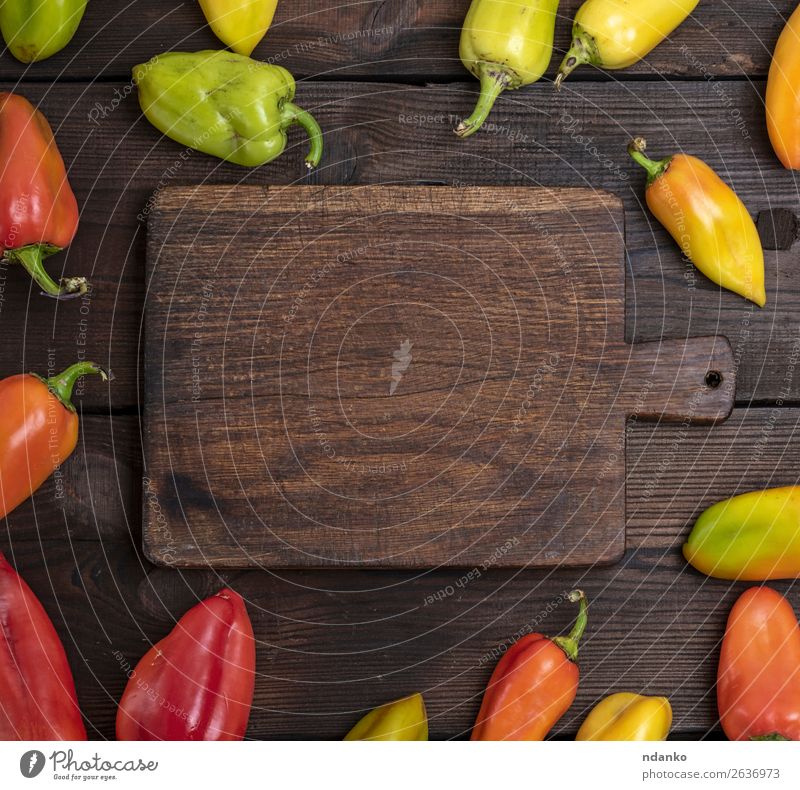 fresh green, yellow and red peppers Vegetable Nutrition Vegetarian diet Table Kitchen Wood Fresh Natural Brown Yellow Green Red Colour Chopping board