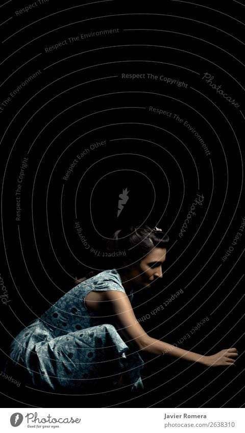 Woman crouched in a blue dress in a dark environment Young woman Youth (Young adults) Dress Sadness Dark Retro Blue Black Caution Concern Longing Loneliness