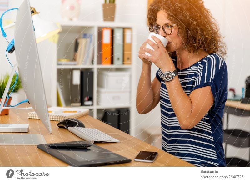 Middle aged woman working on the office and drinking coffee Drinking Coffee Design Happy Relaxation Desk Success Work and employment Profession Workplace Office