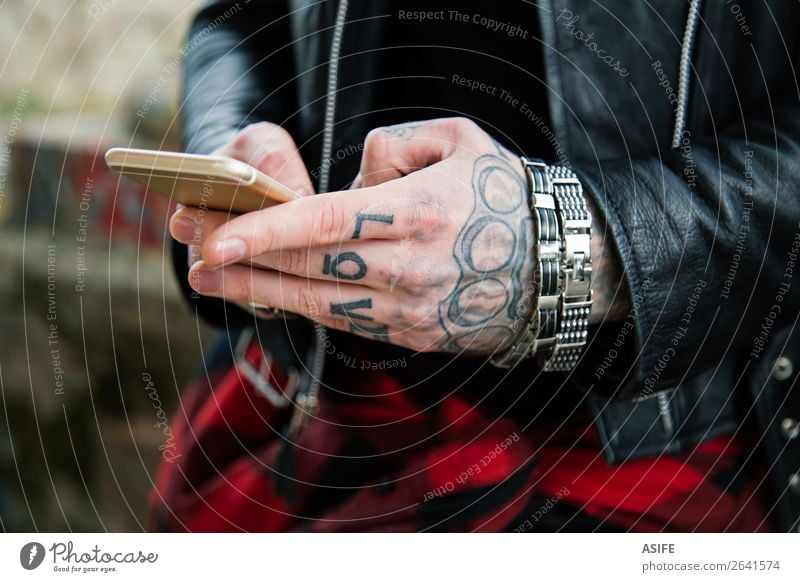 Tattooed man hands with smartphone Telecommunications Telephone PDA Technology Internet Man Adults Hand Fingers Street Jacket Leather Love Modern Black mobile