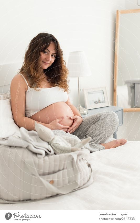 Pregnant woman touching her belly Lifestyle Happy Beautiful Leisure and hobbies Sofa Human being Baby Woman Adults Parents Mother Family & Relations Touch Love