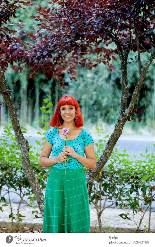 Redhead woman smelling a flower in a park Lifestyle Happy Beautiful Face Wellness Relaxation Fragrance Summer Garden Human being Woman Adults Nature Tree Flower