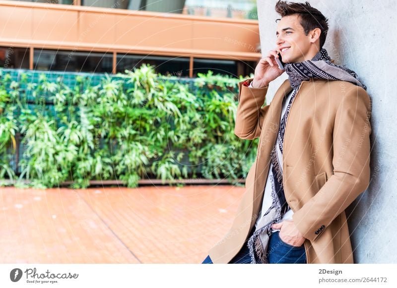Modern young man with mobile phone in the street. Lifestyle Elegant Style Beautiful Hair and hairstyles Winter To talk Telephone PDA Man Adults