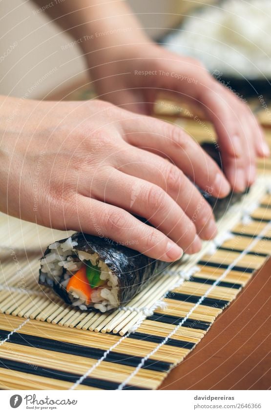 Woman chef hands rolling up japanese sushi Diet Sushi Human being Adults Hand Make Fresh preparing california roll crab stick avocado Rice food sheet girl