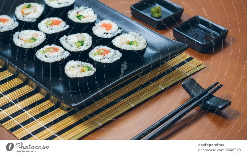 Sushi maki rolls on a tray Plate Elegant Restaurant Make Fresh Black finished Presentation california roll Snack Tray appetizing food japanese rectangular Rice