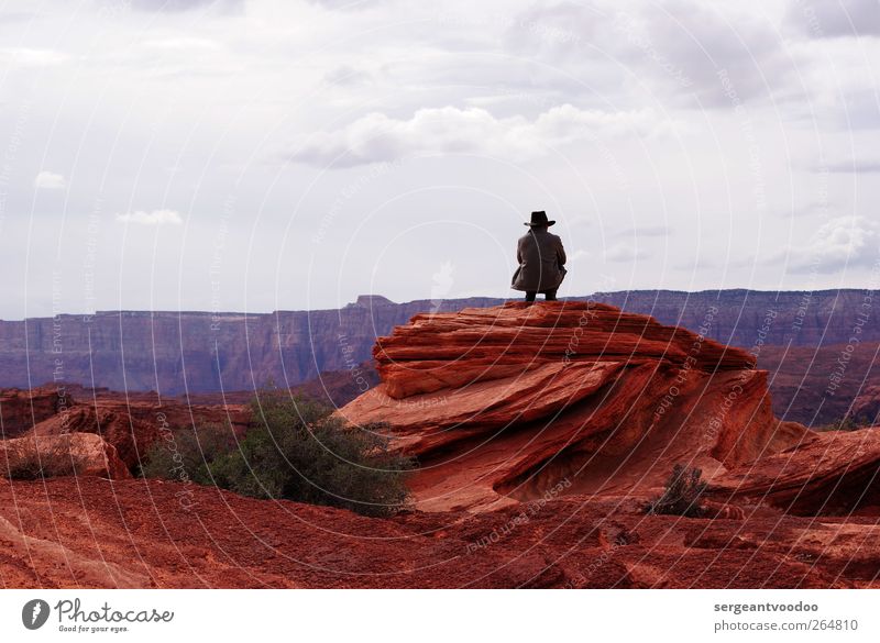 Cowboy on the rocks Man Adults 1 Human being Nature Clouds Horizon Rock Canyon Coat Cowboy hat Observe Relaxation Crouch Dream Cool (slang) Free Infinity Dry