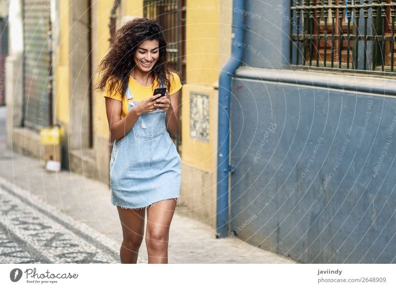 Young African girl walking on the street looking at her smartphone. Lifestyle Style Happy Beautiful Hair and hairstyles Telephone PDA Technology Human being