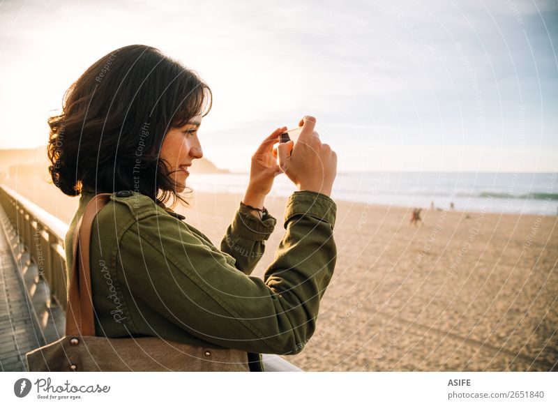 Tourist woman taking pictures with her smart phone Happy Beautiful Leisure and hobbies Vacation & Travel Beach Ocean Telephone Cellphone PDA Technology Woman