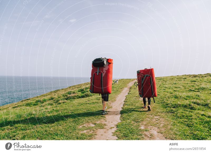 Couple of climbers walking with crash pads at the coast Joy Leisure and hobbies Adventure Ocean Mountain Hiking Sports Climbing Mountaineering Woman Adults Man