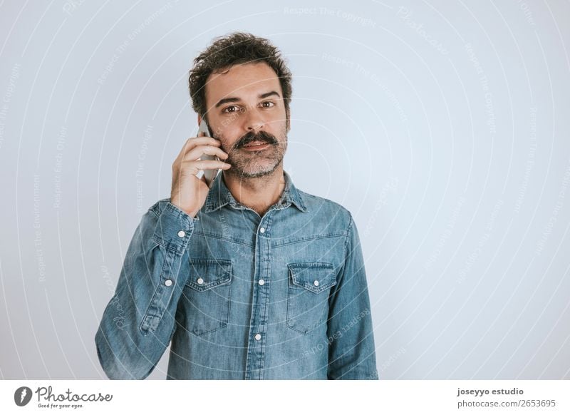 Man with mustache talking on the phone. Lifestyle Face To talk Telephone PDA Human being Adults Fashion Shirt Stand To call someone (telephone) Cool (slang)