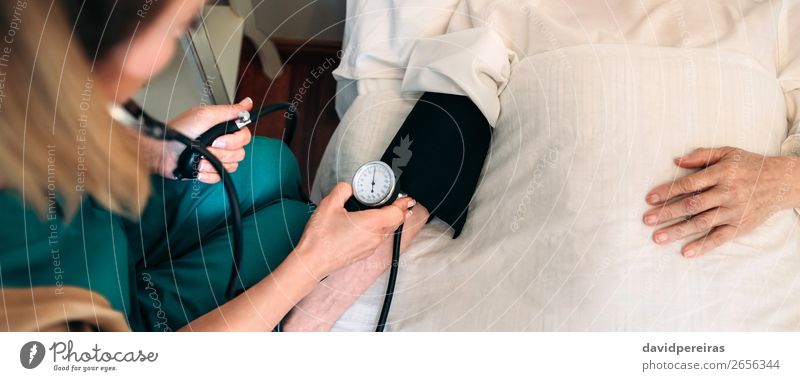 Caregiver checking blood pressure to a senior woman Health care Illness Medication House (Residential Structure) Examinations and Tests Doctor Hospital Internet