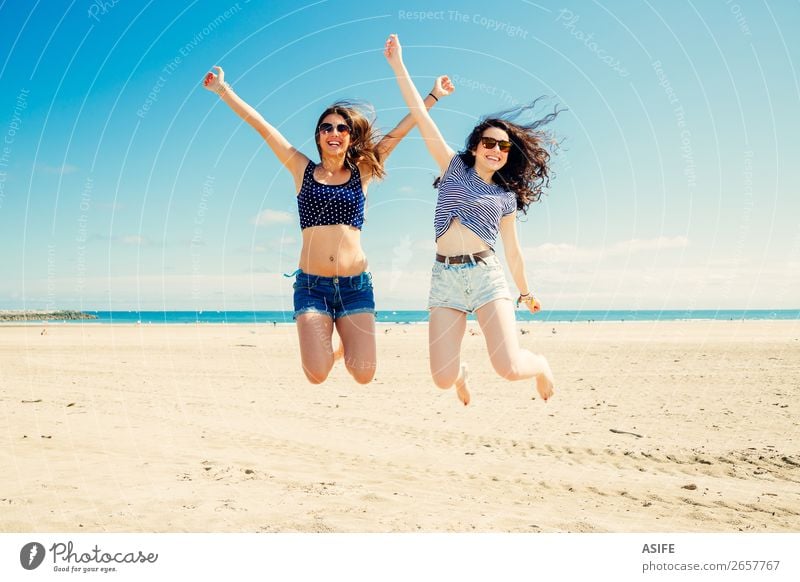 Happy and funny girl friends jumping on the beach, Some blur on legs beacuse of movement Lifestyle Joy Beautiful Vacation & Travel Tourism Summer Beach Ocean