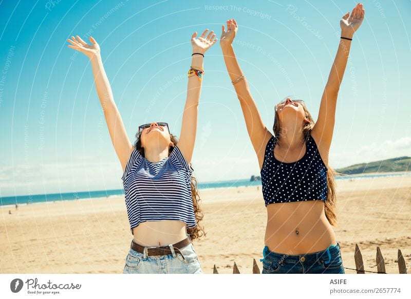 Girls greeting the sun Joy Happy Tourism Summer Beach Ocean Woman Adults Friendship Youth (Young adults) Arm Nature Sand Sky Bikini Sunglasses Smiling Laughter