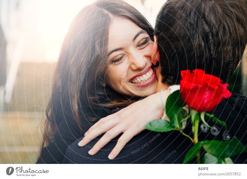 Happy couple in love with a rose Joy Beautiful Winter Feasts & Celebrations Valentine's Day Woman Adults Man Couple Hand Autumn Flower Coat Kissing Smiling
