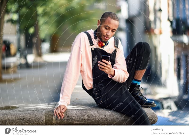 Young black man using smart phone outdoors Lifestyle Happy Beautiful Telephone PDA Technology Human being Masculine Young man Youth (Young adults) Man Adults 1