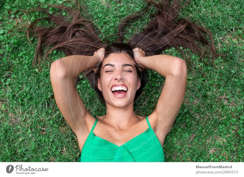 young cheerful woman lying down on the grass Lifestyle Happy Beautiful Leisure and hobbies Summer Human being Woman Adults Nature Grass Park Meadow Smiling