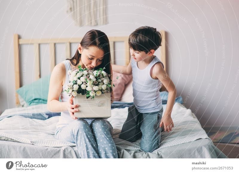 happy child boy giving flowers to mom Lifestyle Joy Bedroom Mother's Day Child Toddler Boy (child) Parents Adults Family & Relations Infancy Flower Smiling Love