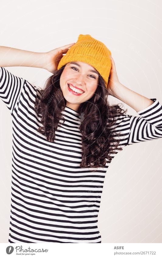 Happy autumn or winter girl with wool cap Beautiful Winter Woman Adults Autumn Dress Brunette Smiling Happiness Funny Yellow Black White Wool isolated ocher