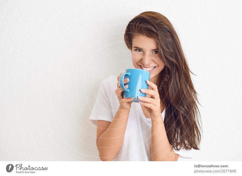 Smiling woman drinking coffee from blue mug Beverage Drinking Coffee Tea Happy Face Woman Adults 1 Human being 18 - 30 years Youth (Young adults) Scream