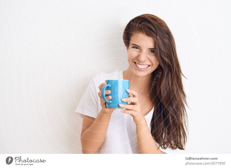 Smiling woman drinking coffee from blue mug Beverage Drinking Coffee Tea Happy Face Woman Adults 1 Human being 18 - 30 years Youth (Young adults) Scream
