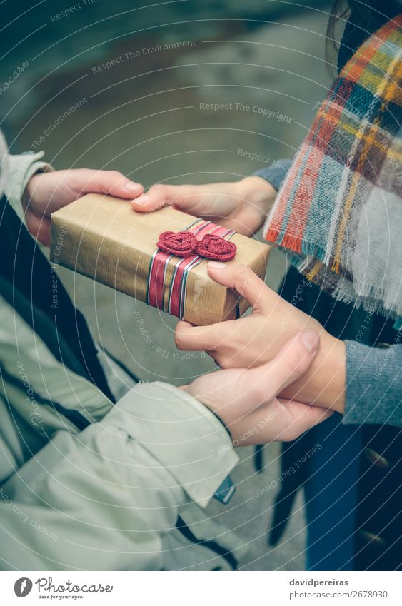 Man hands giving gift box to woman with scarf Lifestyle Happy Winter Feasts & Celebrations Birthday Human being Woman Adults Couple Hand Autumn Flower Street