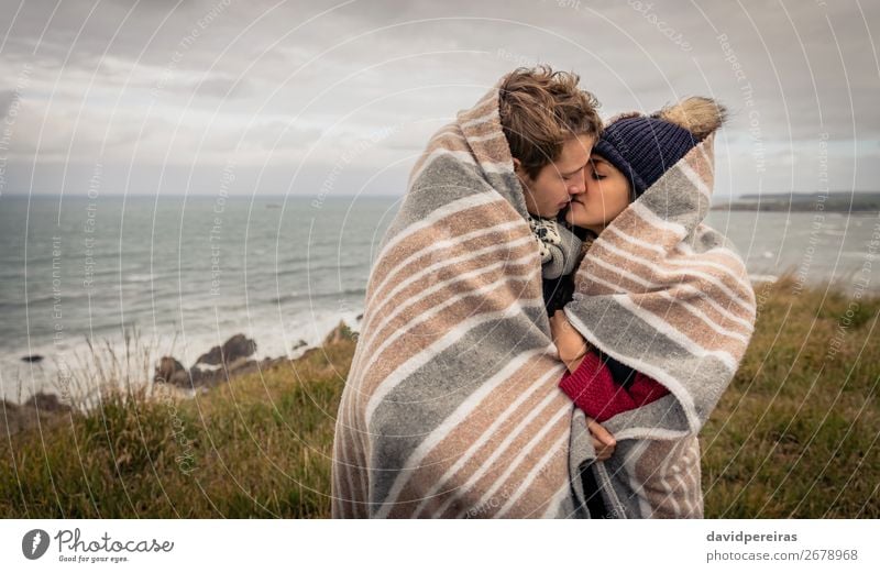 Young couple kissing outdoors under blanket in a cold day Lifestyle Happy Beautiful Ocean Winter Mountain Woman Adults Man Couple Nature Sky Clouds Autumn