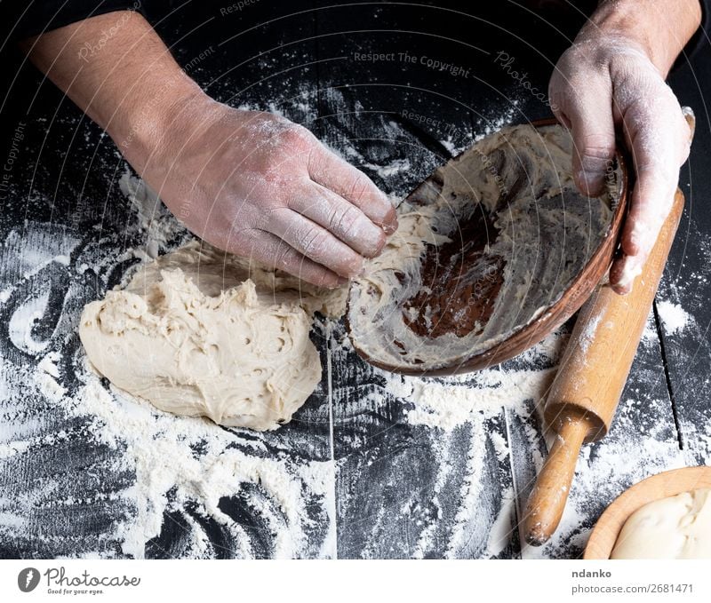 man's hands knead white wheat flour dough Dough Baked goods Bread Nutrition Plate Table Kitchen Cook Man Adults Wood Make Black White Tradition Meal board