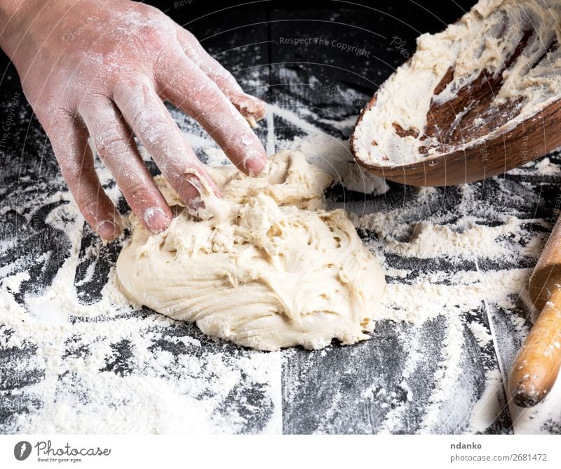man's hands knead white wheat flour dough Dough Baked goods Bread Nutrition Plate Table Kitchen Man Adults Make Black Tradition Flour Baker kneading Bakery