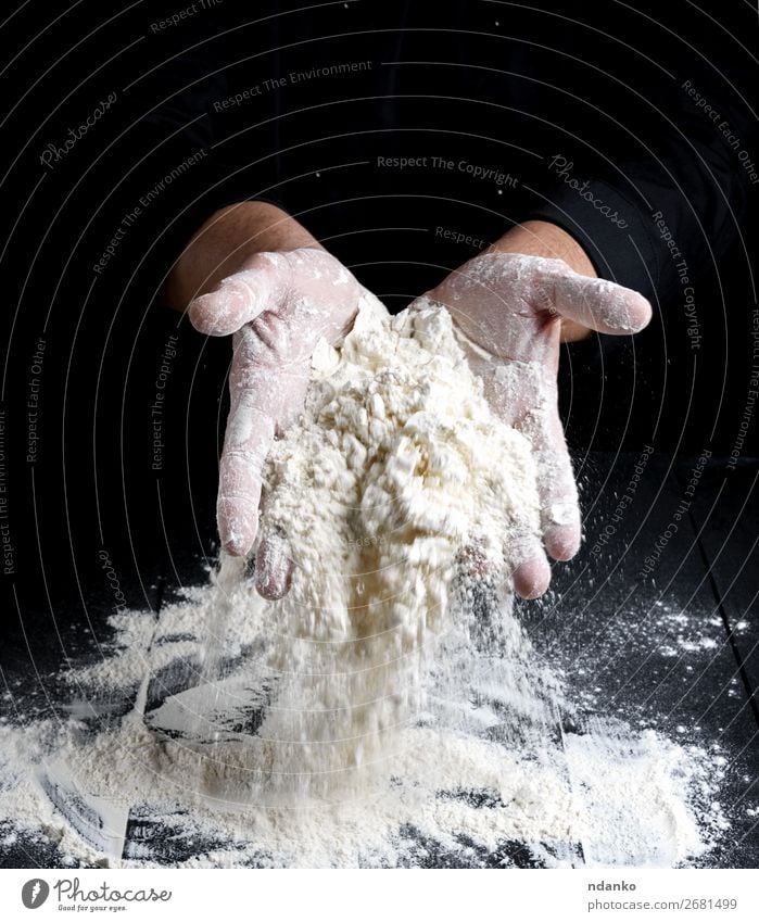 white wheat flour in male hands Dough Baked goods Bread Table Kitchen Cook Human being Man Adults Hand Wood Make Dark Black White Hold Meal Wheat Bakery board